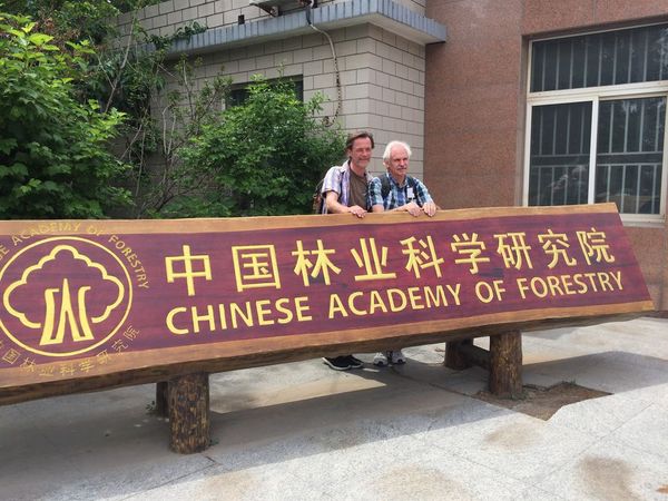 Zwei Personen stehen hinter einem Schild mit der Aufschrift "Chinese Academy of forestry"