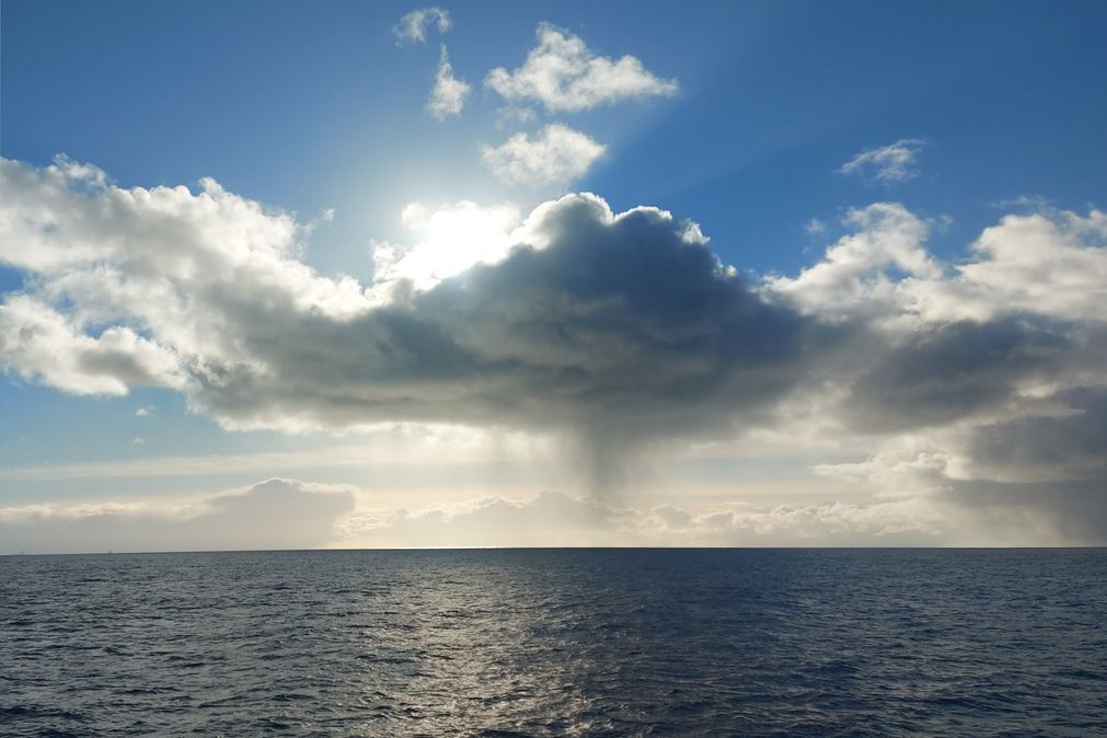 View of the sea with a cloud formation in front of the sun