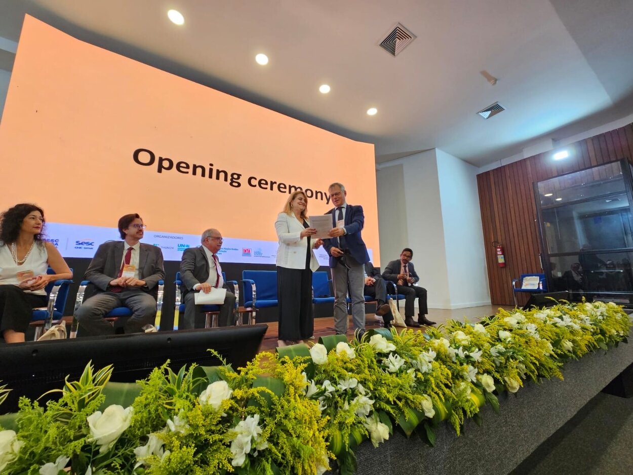 Several people sit and stand on a stage