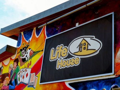 Die Abbildung zeigt die Fassade des Life House in Stemwede, mit dem Logo des Hauses und bunter Graffiti an der Wand.ugendarbeit im ländlichen Raum angeboten wird.