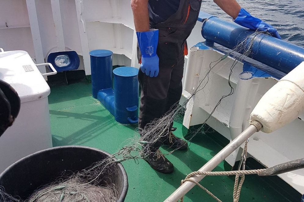 Mann an Bord eines Schiffes mit Netz