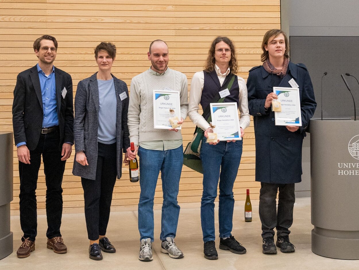 Die drei Preisträger mit zwei Organisatoren und den Siegerurkunden
