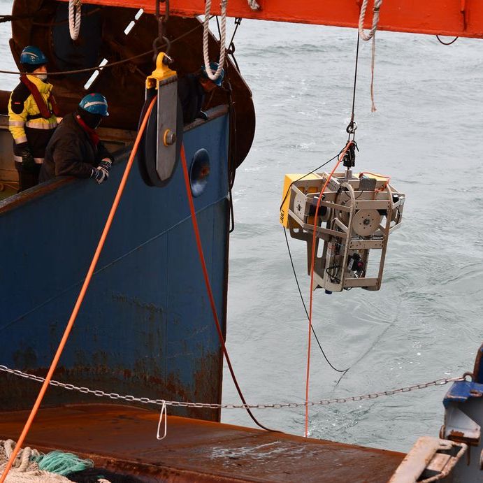 Ein ROTV mit einer Unterwasserkamera hängt am Kran und wird wieder aus dem Wasser geholt