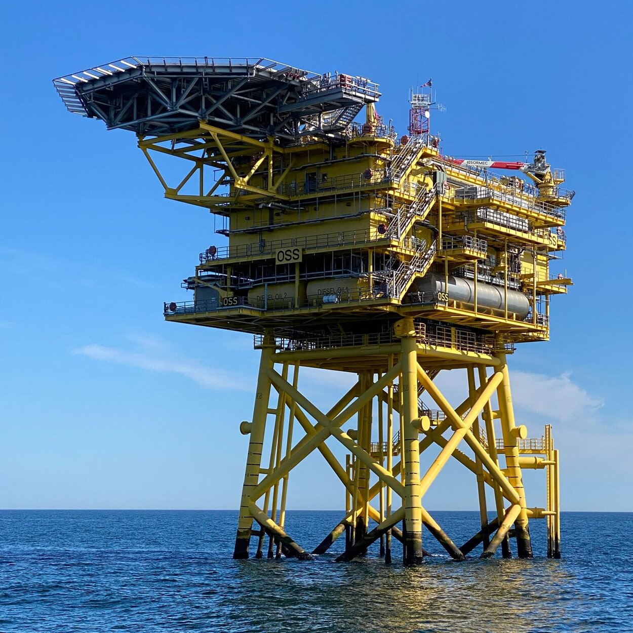 Ein auf einer Stahlkonstruktion stehendes Gebäude mit einer Landeplattform für Hubschrauber auf hoher See.