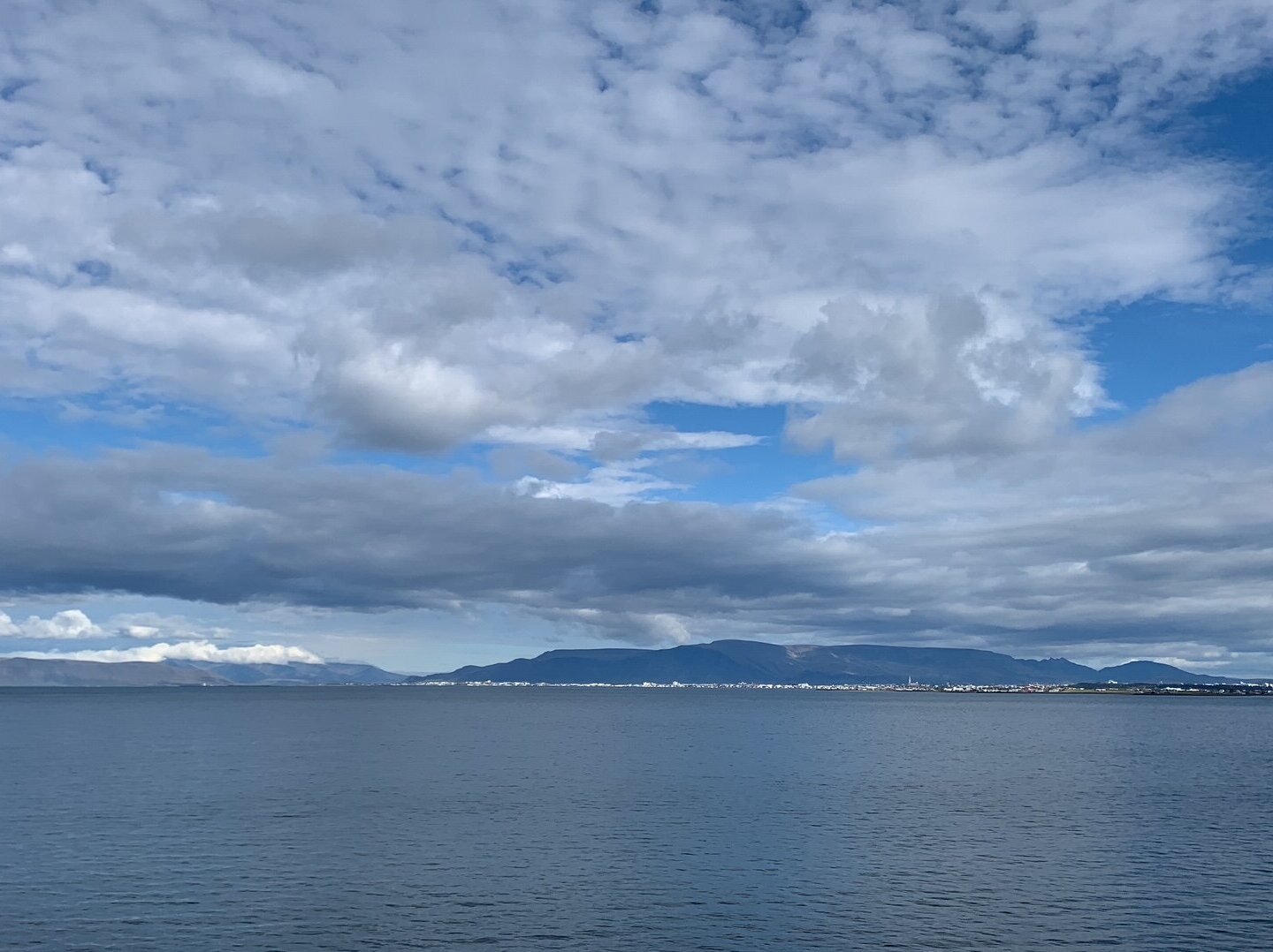 Meer und Wolken vor blauem Himmel.