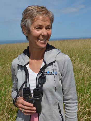 Juliet Vickery Foto der Ornithologin Juliet Vickery mit einem Feldstecher im Freiland