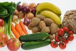 Bananen, Äpfel, Tomaten, Frühlingszwiebeln, Kartoffeln, Salat, Zwiebeln, Gurke, Möhren und Vollkornbrot auf einem Bild