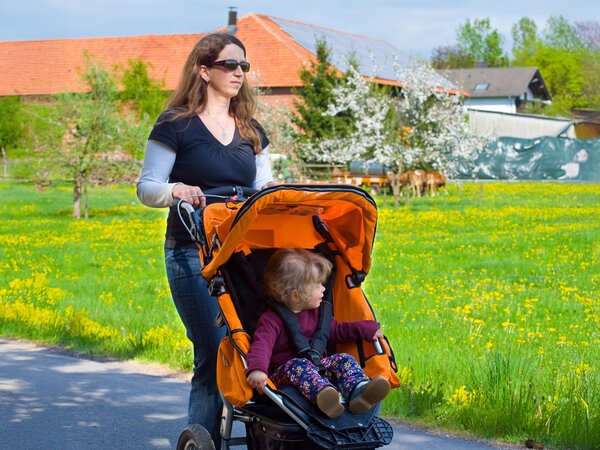 Many single mothers in rural areas appreciate the quiet and nature. A woman with a toddler in a pram.