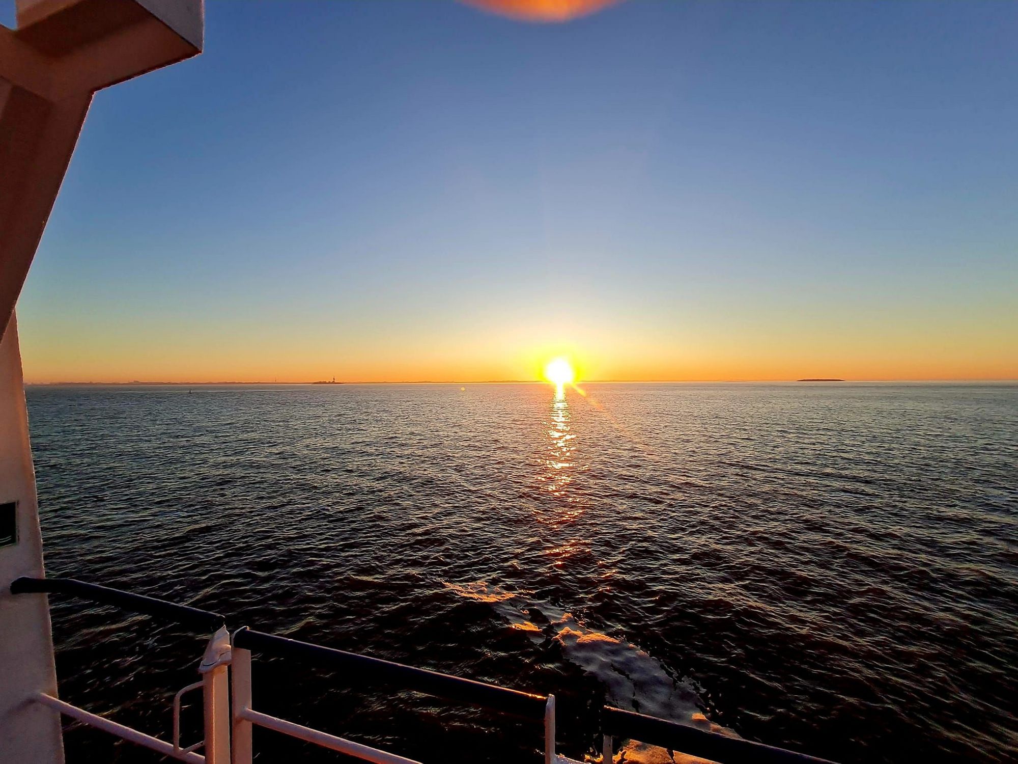 Blick vom Deck des Forschungsschiffs auf die tief stehende Sonne.