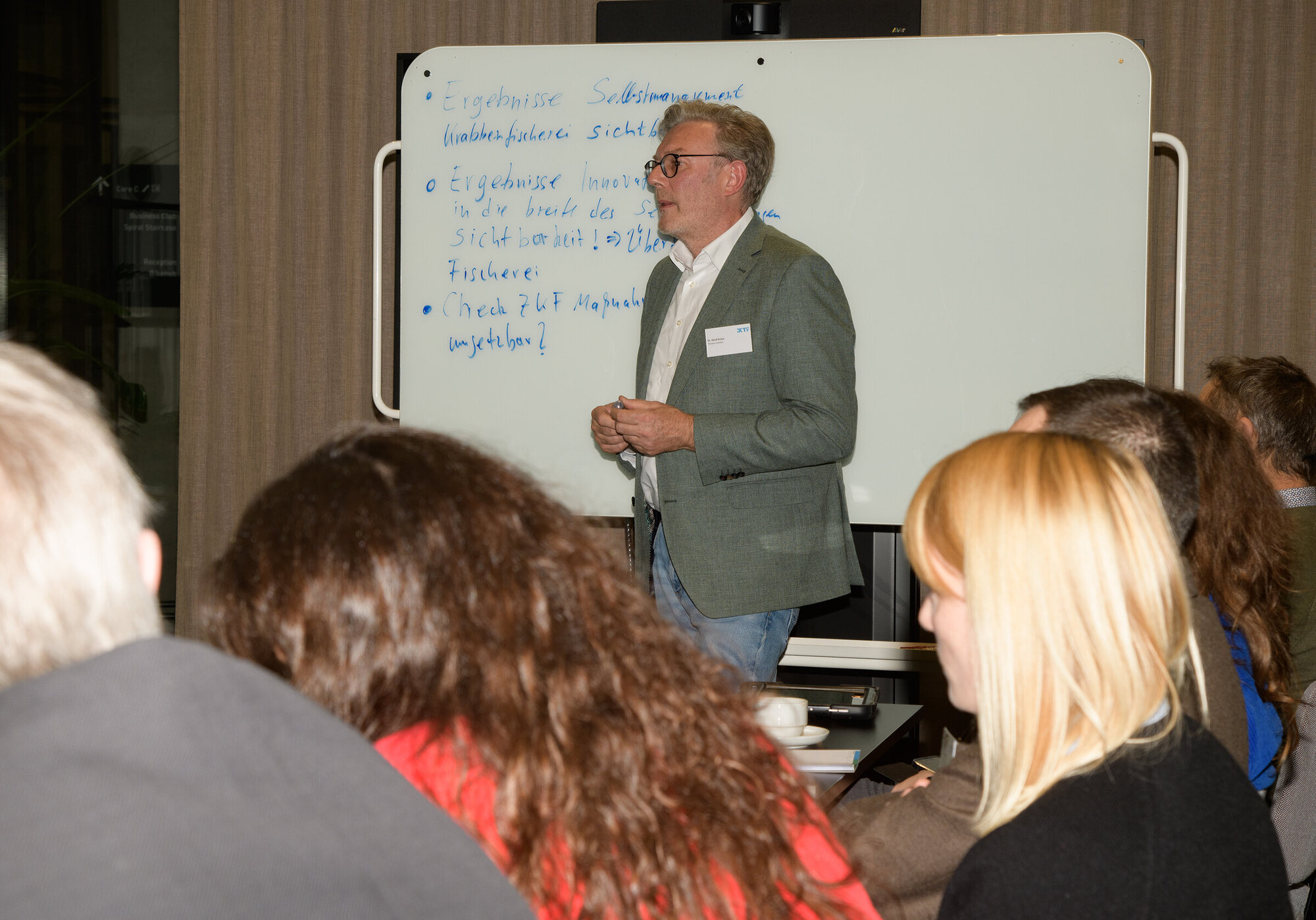 Dialogue workshop: Fisheries management A person is standing at a blackboard, writing down notes.