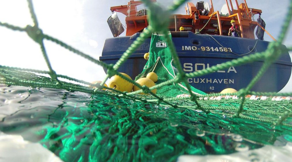 Aussetzen eines Schleppnetzes über das Heck des Fischereiforschungsschiffes „Solea“, aus der Perspektive eines Schwimmers.
