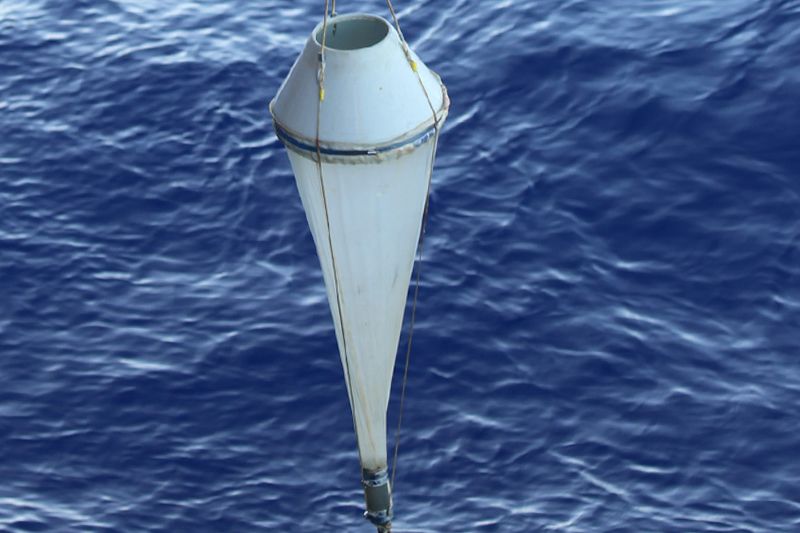 Ein Planktonnetz hängt an einem Haken über dem Meer