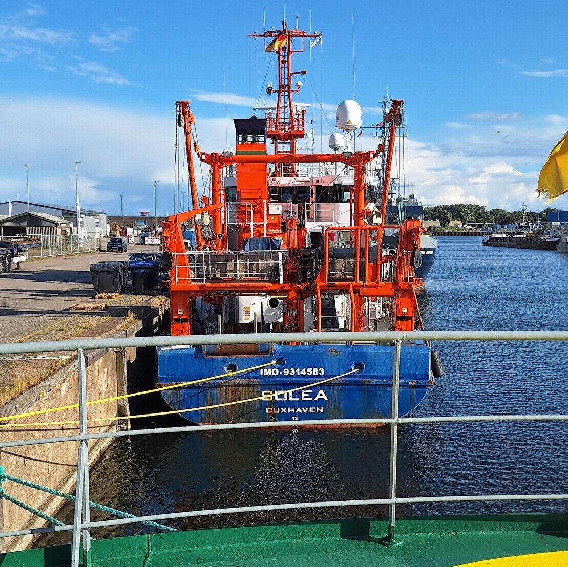 Blick über eiinen in grün und gelb bemalten Boden auf das Heck des Fischereiforschungsschiffs Solea.