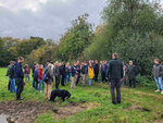 Project team for the excursion stands in front of a hedge