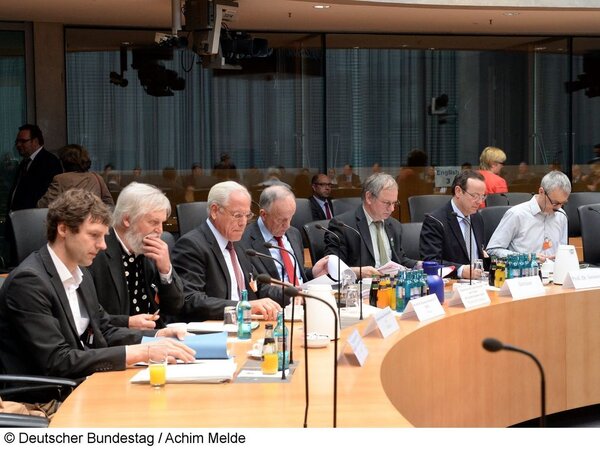 Die Herren vom Ausschuss sitzen am runden Tisch, zur Disskusion bereit.