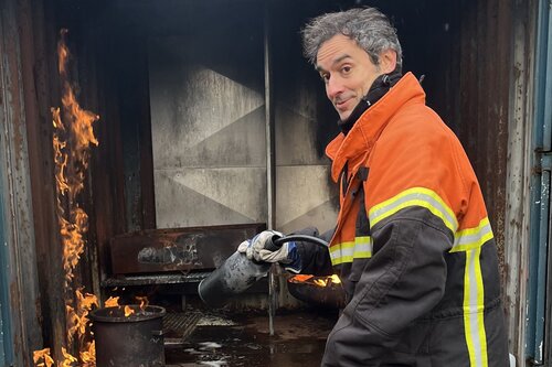 Person löscht Feuer