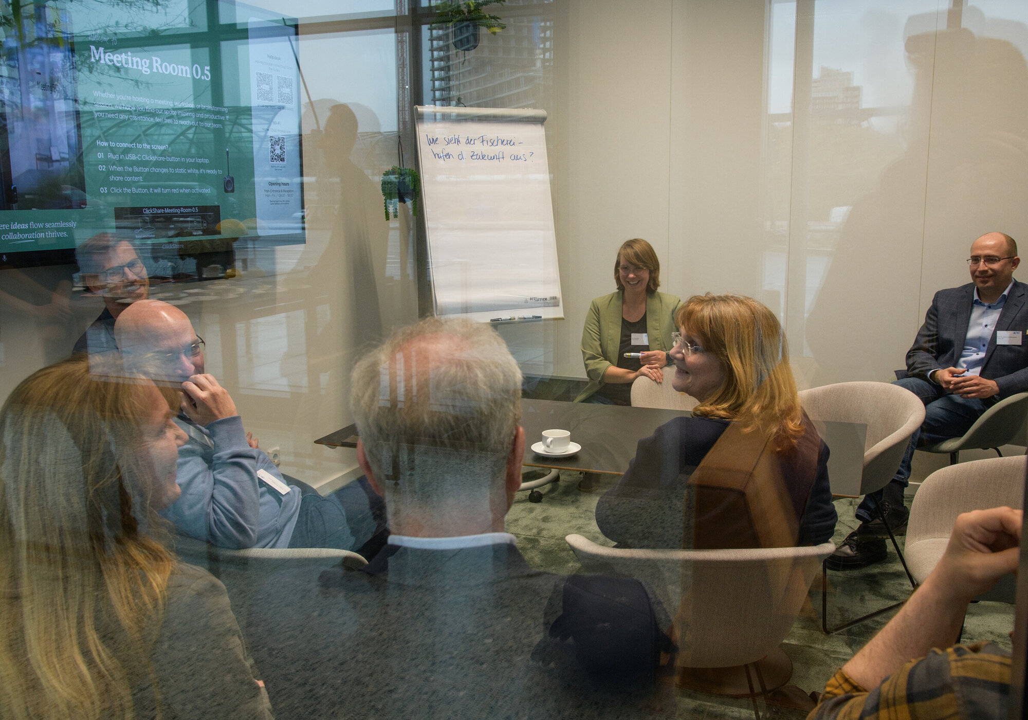 Dialogue Workshop: Ports of the Future Several people are chatting around a table.