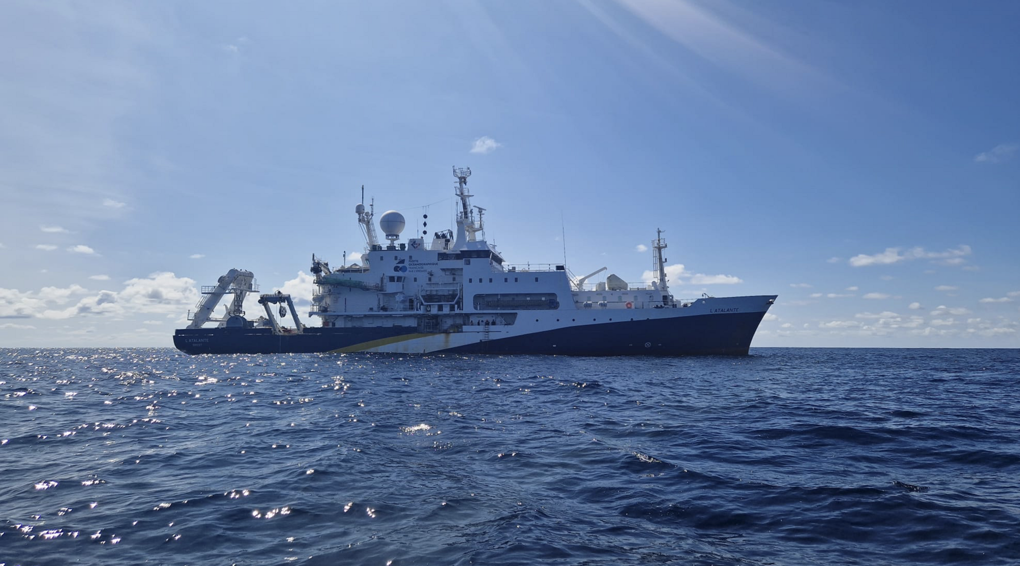 Das französische Forschungsschiff L'Atalante. Ein Schiff von der Seite ist auf dem Meer unterwegs.