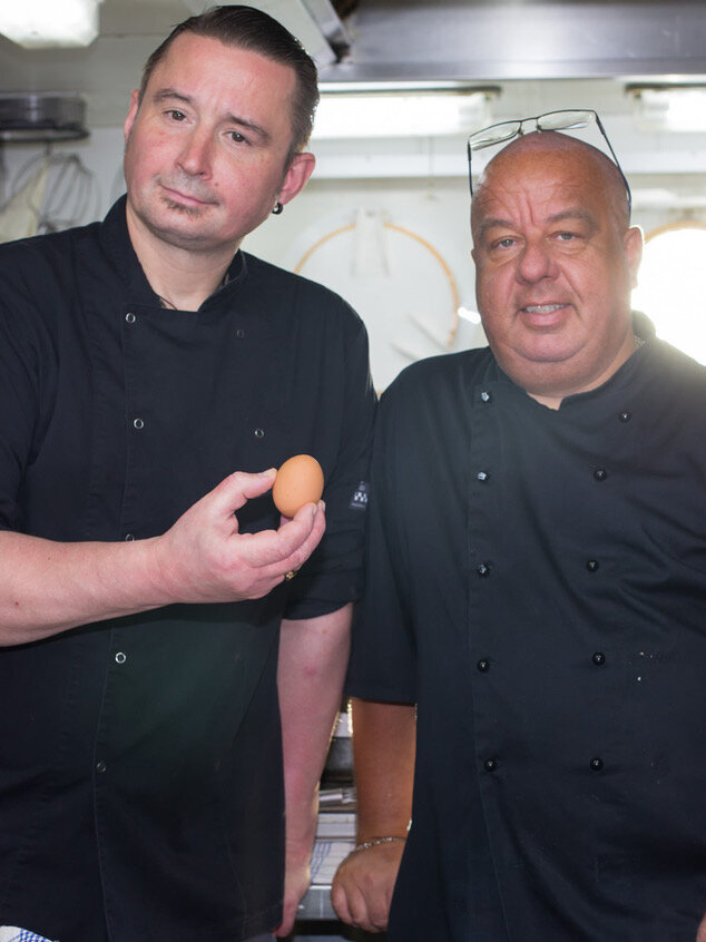 Die beiden Schiffsköche mit einem Ei.