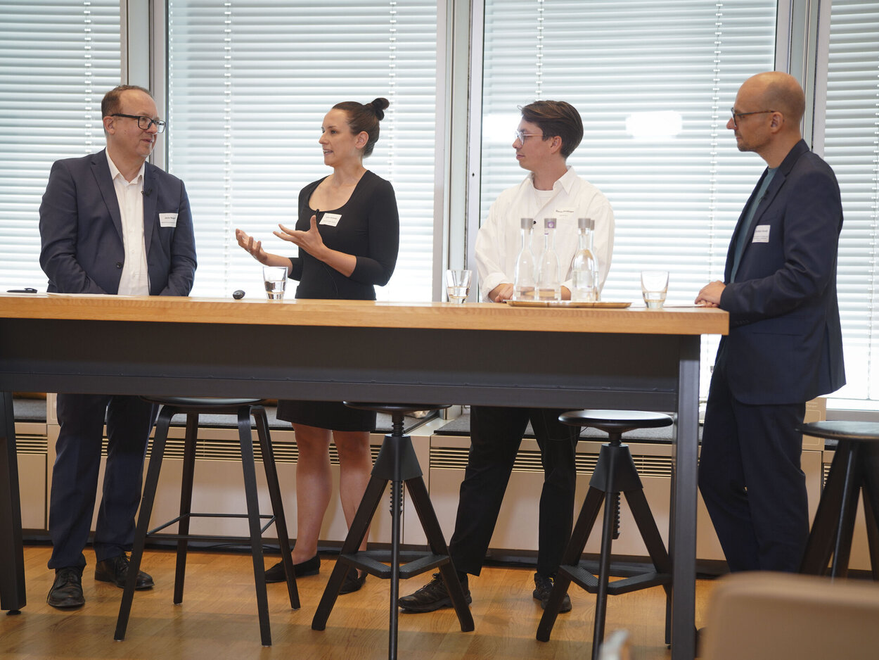 Four people are standing at a table.