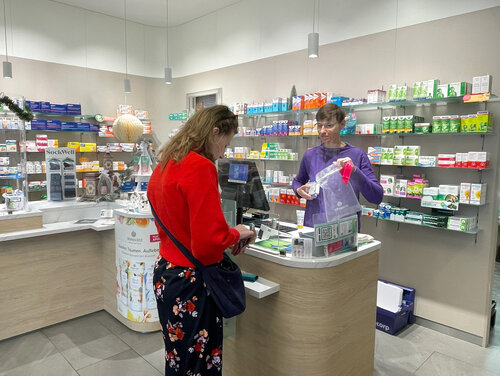 Eine Apothekerin übergibt der Kundin ihre Medikamente.