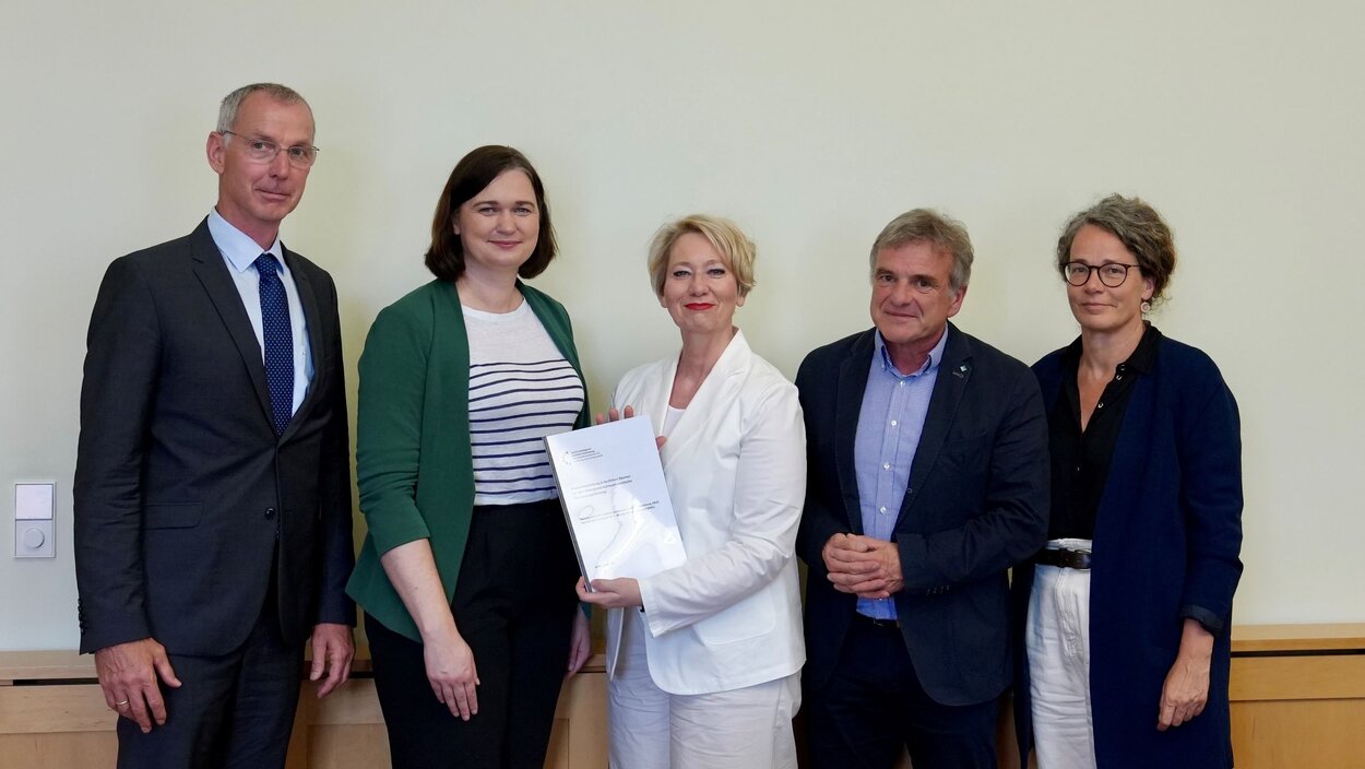Mitglieder des Sachverständigenrats übergeben die Stellungnahme an die Vertreterin des Ministeriums