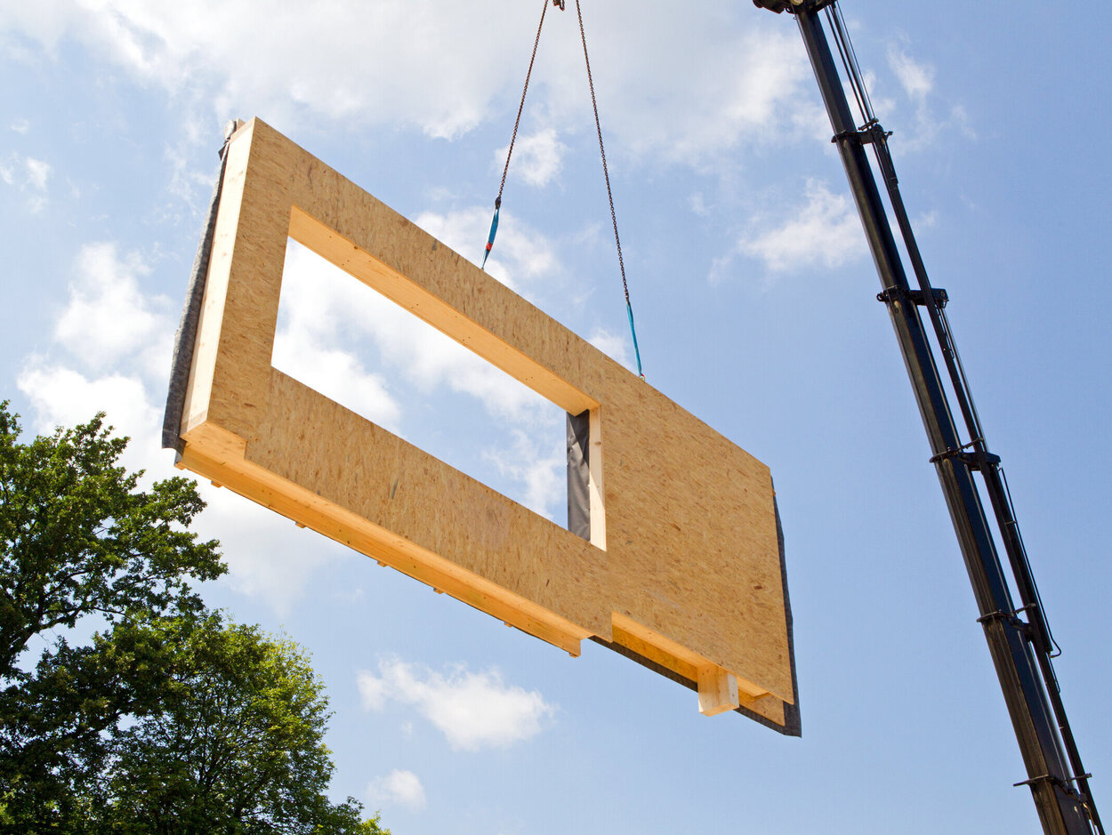 Modular components can be reused without compromising the quality of the wood. Part of the house is currently being lifted into the air by the crane.