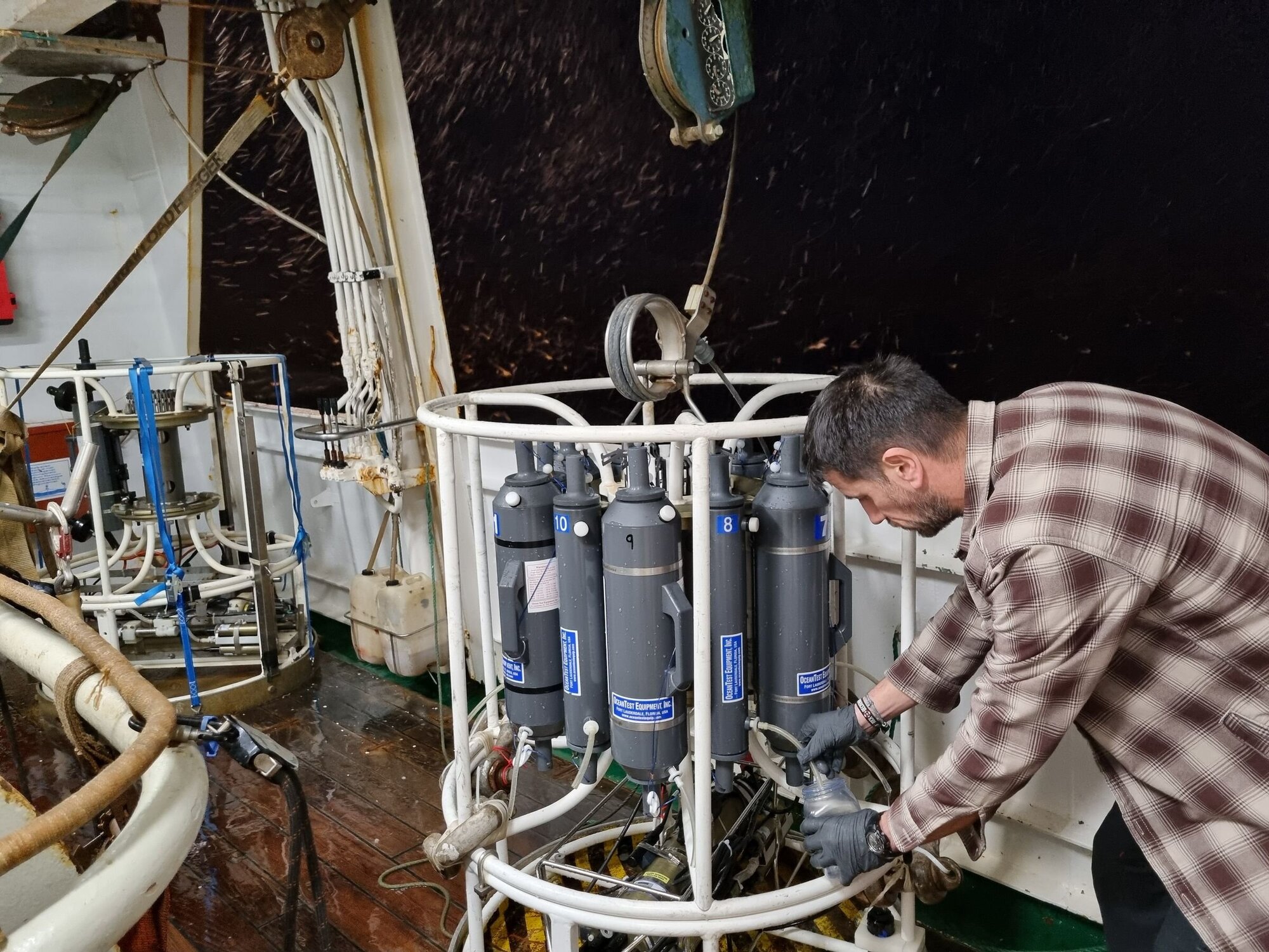 Fahrtleiter Hermann Neumann nimmt an Deck Wasserproben aus der Tiefe für die weitere Untersuchung.