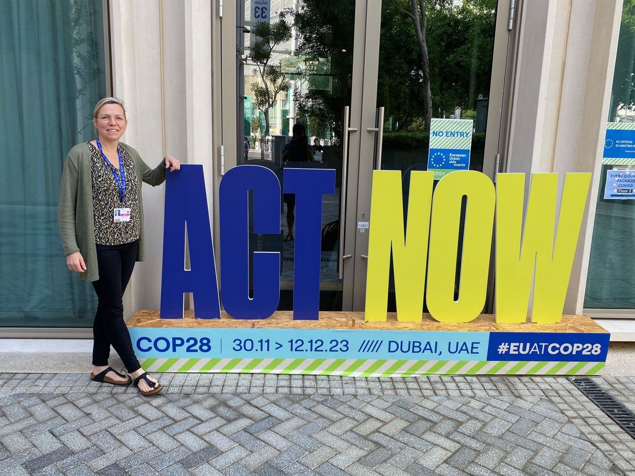 Die Wissenschaftlerin Claudia Heidecke stet neben dem "Act Now"-Schriftzug bei der COP28 in Dubai. Boden als Teil der deutschen Delegation bei der COP28 in Dubai.