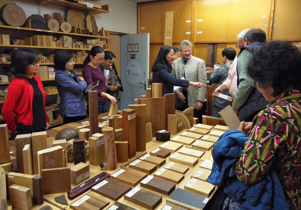 Chinesische Personen stehen um einen Tisch mit verschiedenen Hostmustern