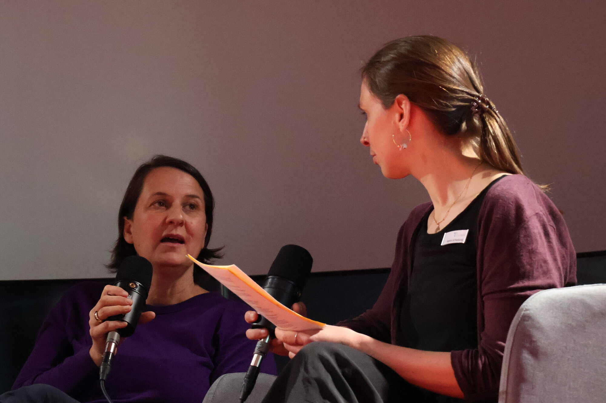 Dr. Zazie von Davier und Moderatorin Dr. Katrin Schiedung im Gespräch. Zwei Frauen auf einer Bühne, eine spricht in ein Mikrofon.