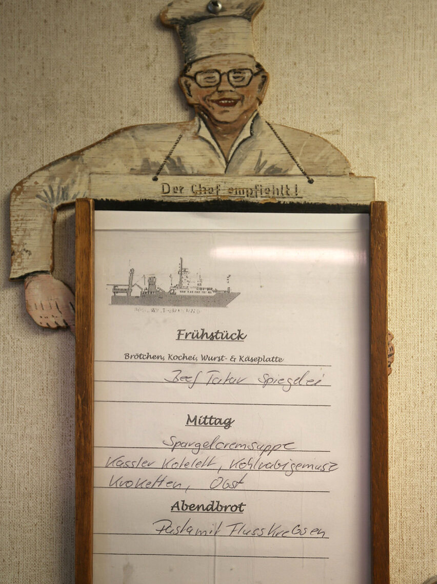 Speisekarte an der Wand mit den drei warmen Mahlzeiten.