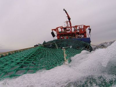 Blick über das Netz im Wasser auf das Fischereiforschungsschiff Solea