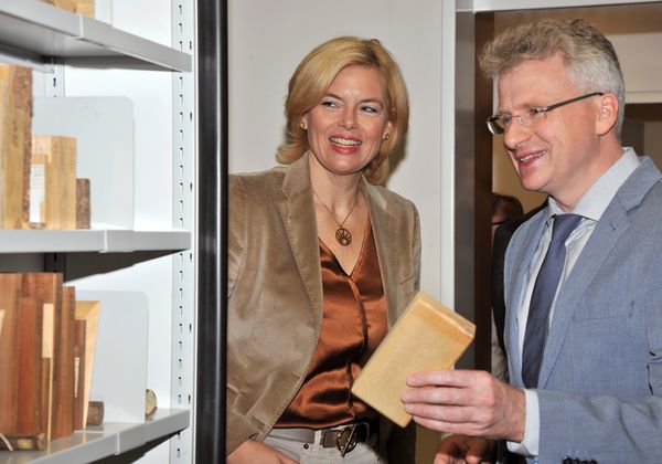 Bundeslandwirtschaftsministerin Julia Klöckner schaut sich mit einem Thünen-Mitarbeiter Holzproben an