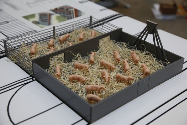 Model eines Schweinestalls mit Stroh auf dem Boden und offenem Zugang zur Freifläche