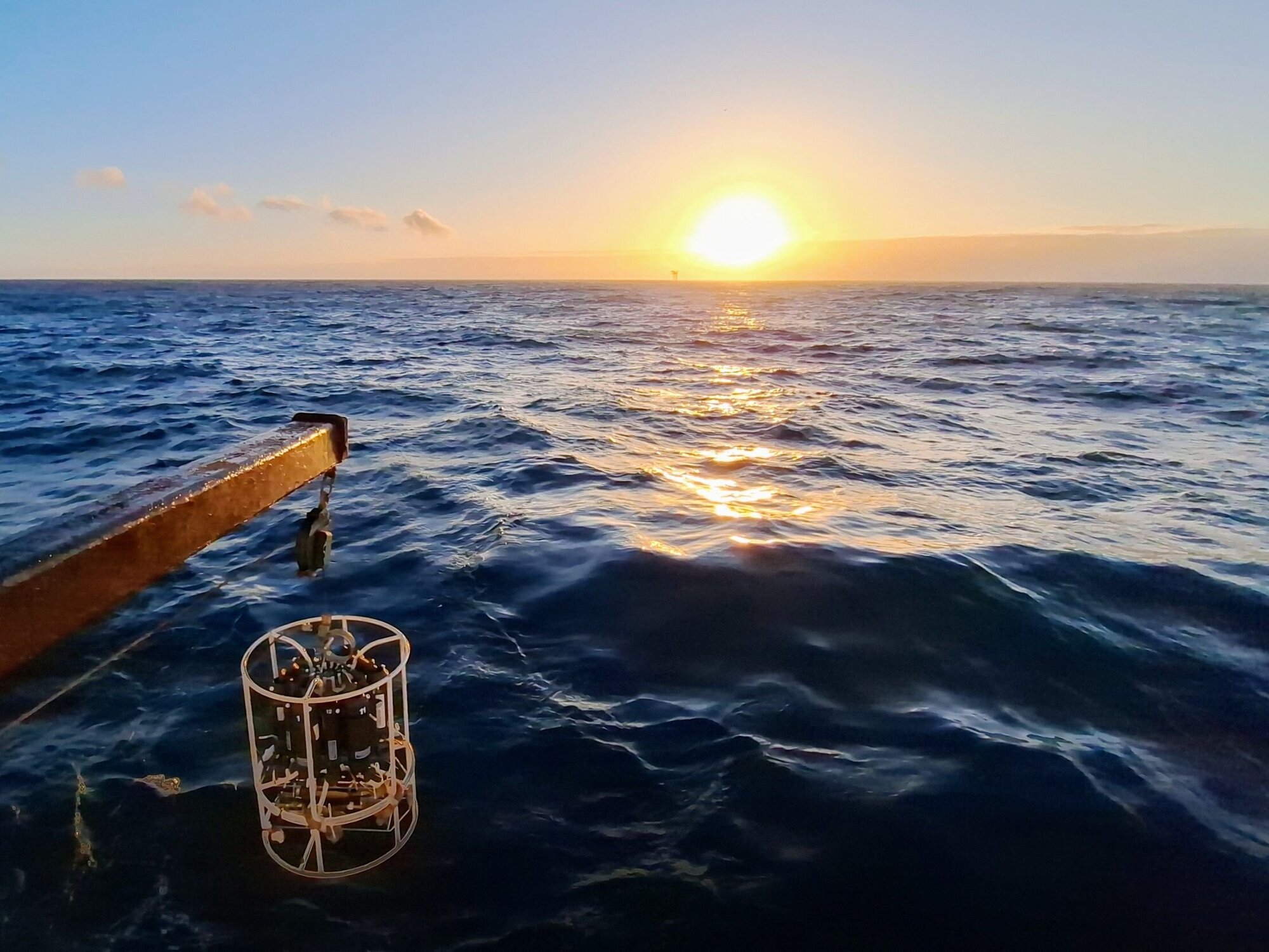 Die CTD-Rosette, eine Sonde mit mehreren zylinderförmigen Röhren zur Aufnahme von Meerwasserproben aus verschiedenen Tiefen,  wird zu Wasser gelassen.