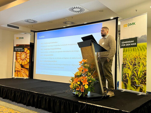 Auf dem Maiskomitee ist Masud Heydarli auf einem Rednerpult zu sehen.