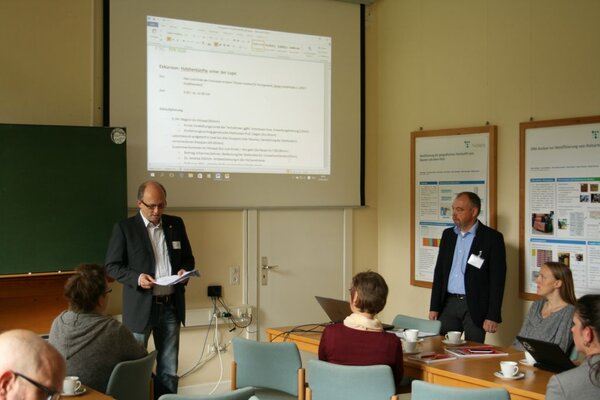 Ein Mann hält einen Vortrag vor anderen Personen.