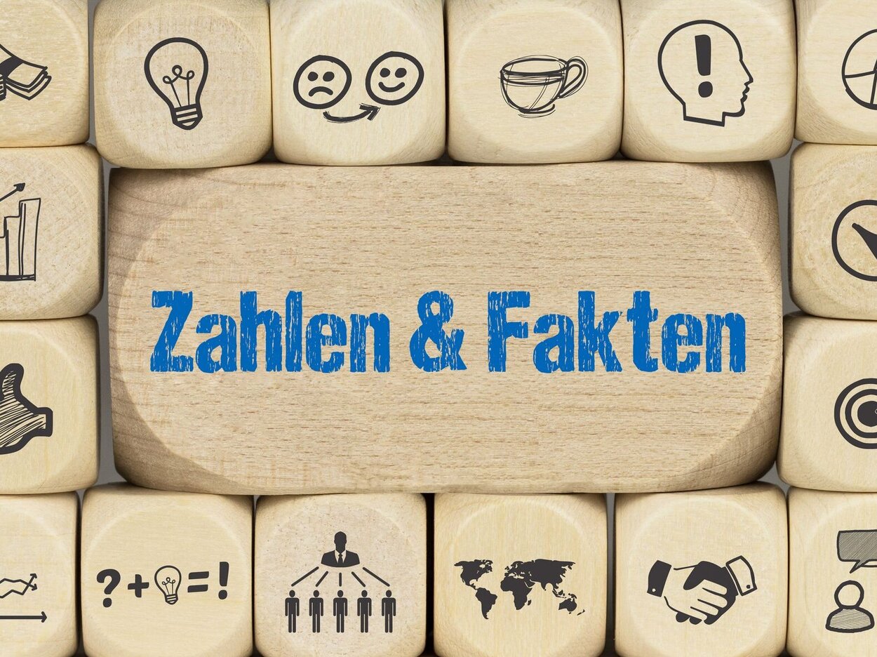 Zahlen & Fakten Cubes with different symbols stacked on top of each other as a background.