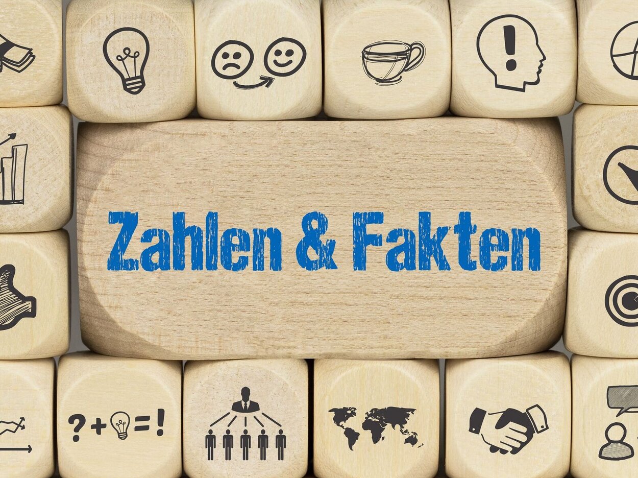 Würfel mit unterschiedlichen Symbolen als Hintergrund aufeinandergestapelt.