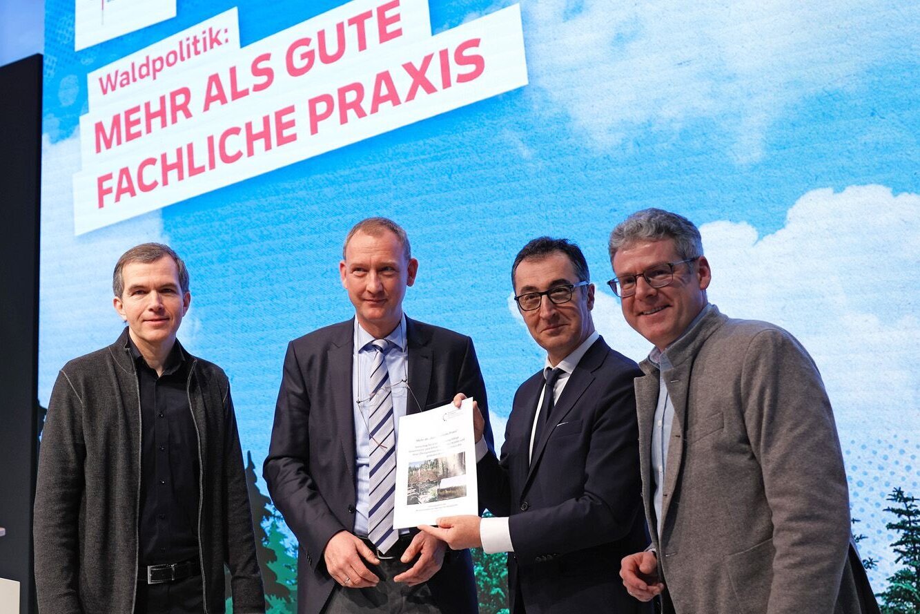 Bundesminister Özdemir mit drei Wissenschaftlern auf der Bähne in der BMEL-Halle.