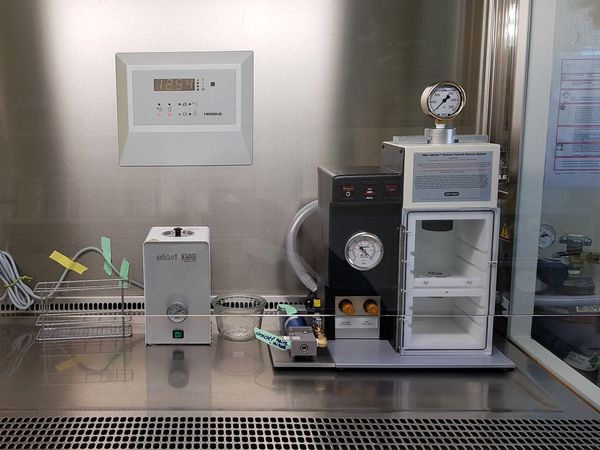 In einer Sterilwerkbank stehen unterschiedliche Geräte, darunter rechts eine Partikelkanone.
