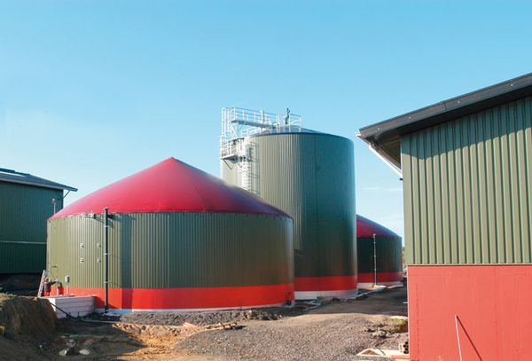 Mehrere runde Gebäude mit einem spitzen kegelförmigen Dach beherbergen eine Biogasanlage