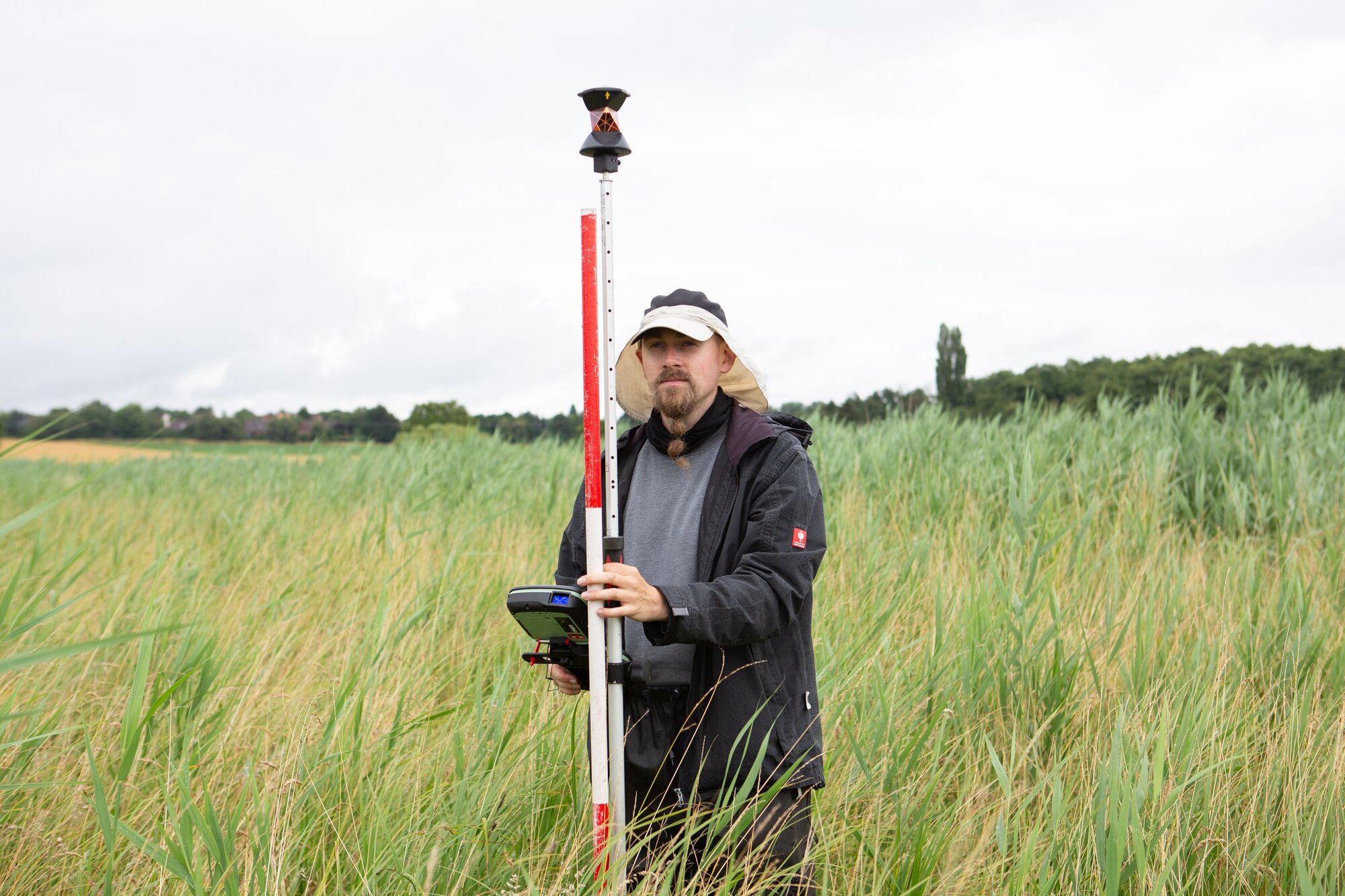 Mann mit Messgerät zur Vermessung der Geländehöhen