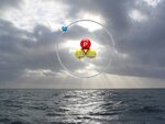 Symbolbild für Tritium im Meer: Ein Tritium-Atom vor einem Meeresbild. 