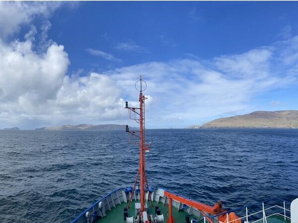 Blick vom Schiff zum Land mit Wolken