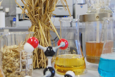 Stroh und verschiedene Chemieprodukte in einem Labor