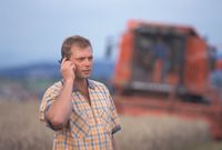 Telefonische Verhandlung eines Bio-Bauern während der Erntearbeiten.