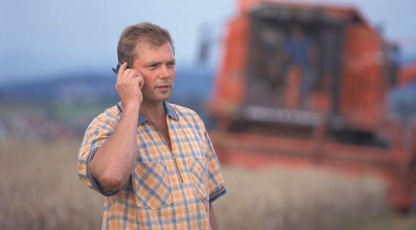 Telefonische Verhandlung eines Bio-Bauern während der Erntearbeiten.