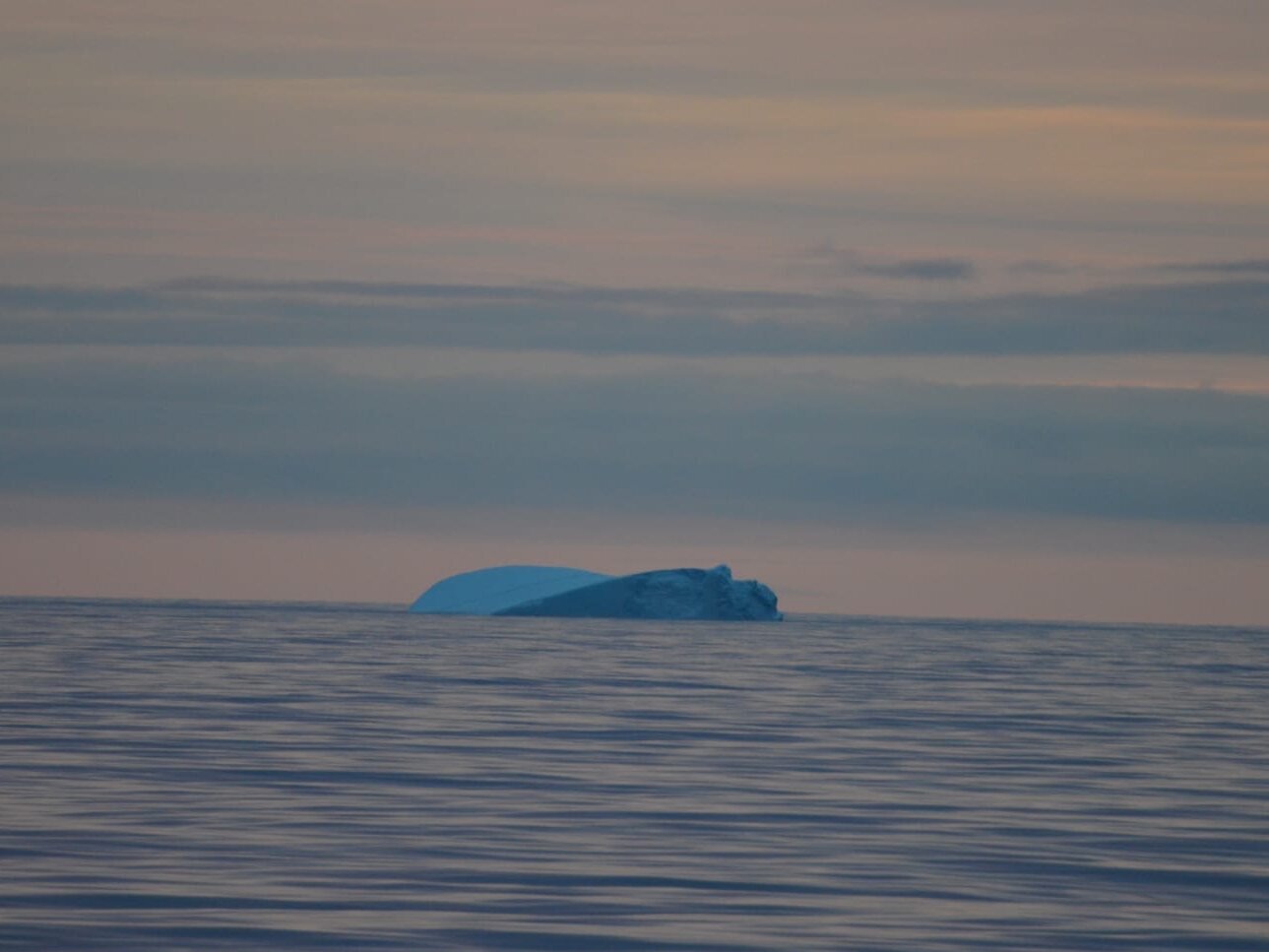 Ein Eisberg treibt auf dem Meer.